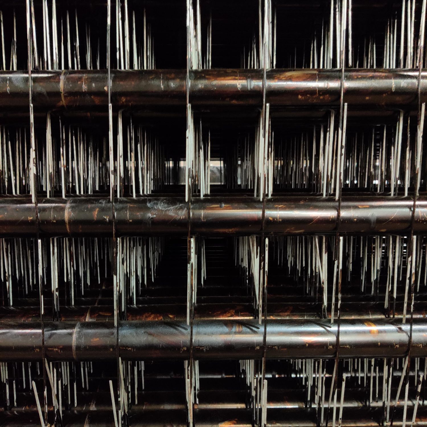 Barbed ESP discharge electrodes mounted on tubular support frames, corona-emitting points visible along each element