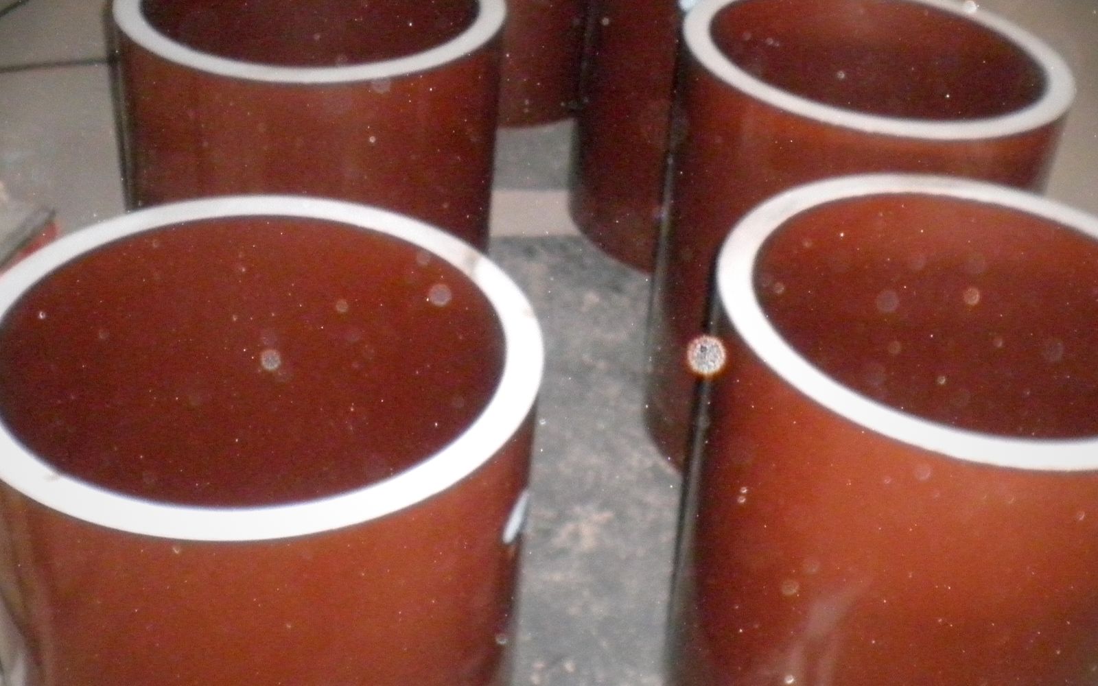 Glazed cylindrical ceramic ESP insulators with white sealing rings, ready for despatch at the works