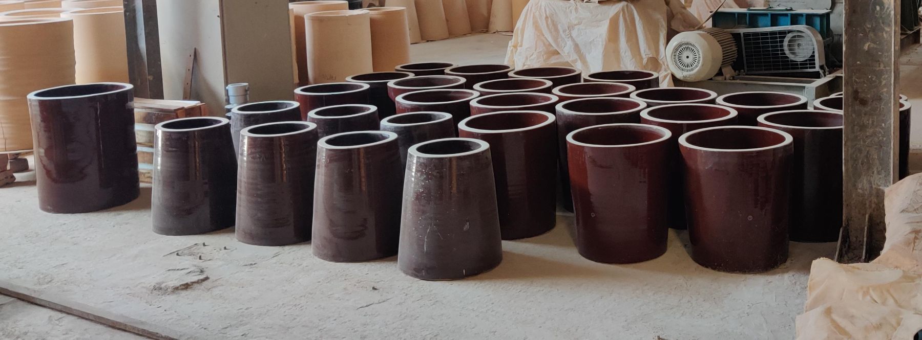Glazed hollow ceramic support insulators for electrostatic precipitators, cylindrical and conical, on the works floor