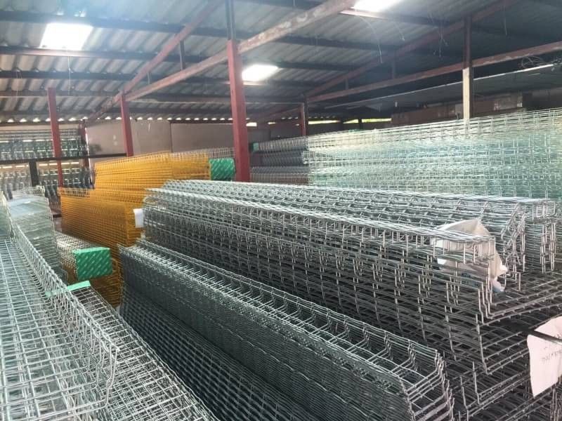 Bundled wire mesh trays and accessories stacked in a supply warehouse