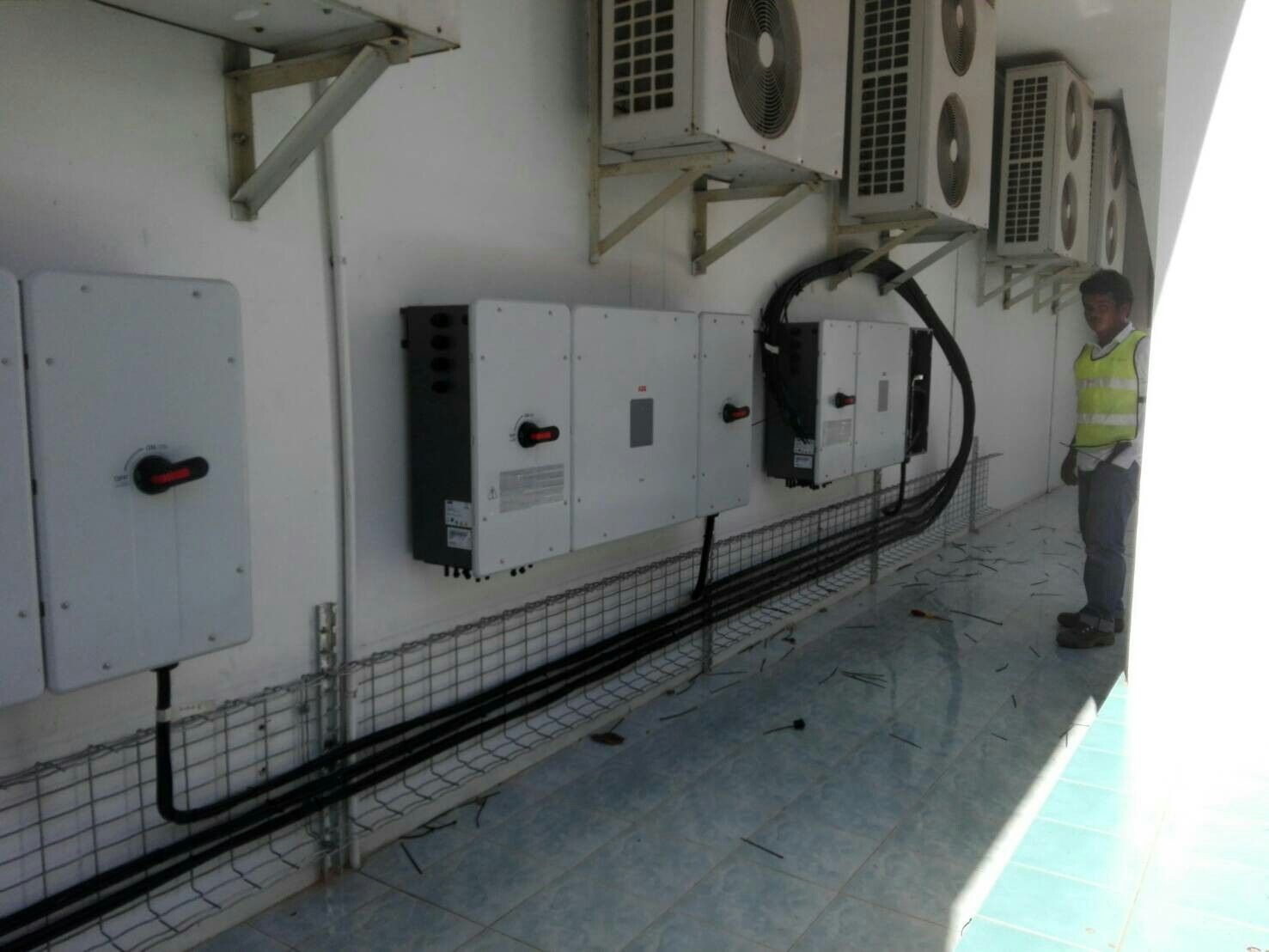 Wire mesh tray running along a wall carrying cables to wall mounted inverters